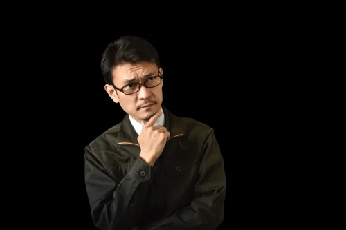 作業着を着て悩む男性